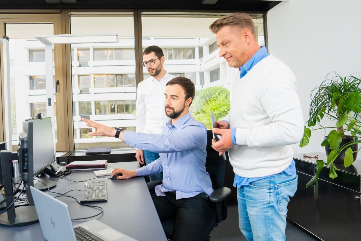 Drei greentech-Experten analysieren am Computer mit dem Repowering-Tool die wirtschaftlichen Potenziale einer Photovoltaik-Anlage.