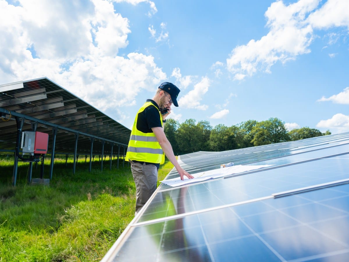 Ein Ingenieur mit Praxiserfahrung plant ein Revamping PV Konzept anhand von Bauplänen direkt in einem Solarpark.